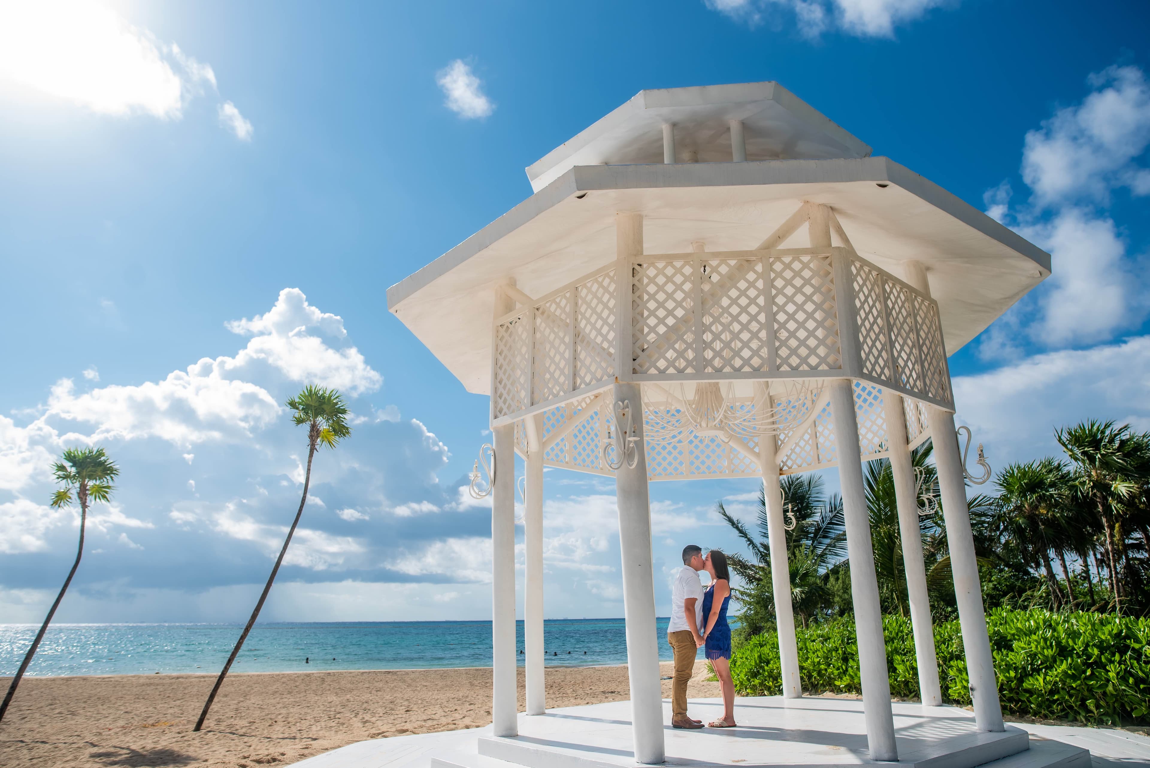 Eli and Hannah in a white gazebo on the beach.