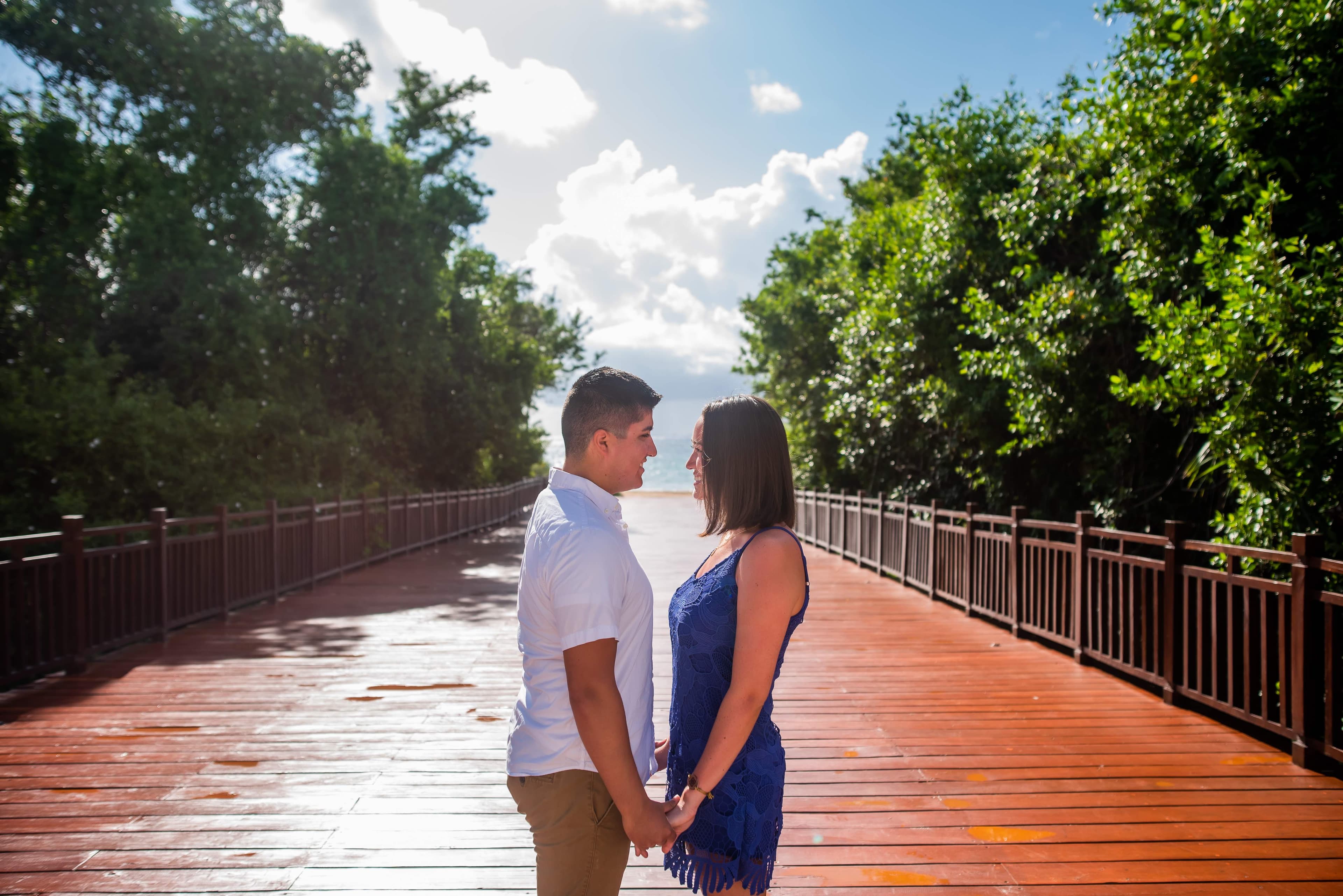 Eli and Hannah on a wooden bridge holding hands.