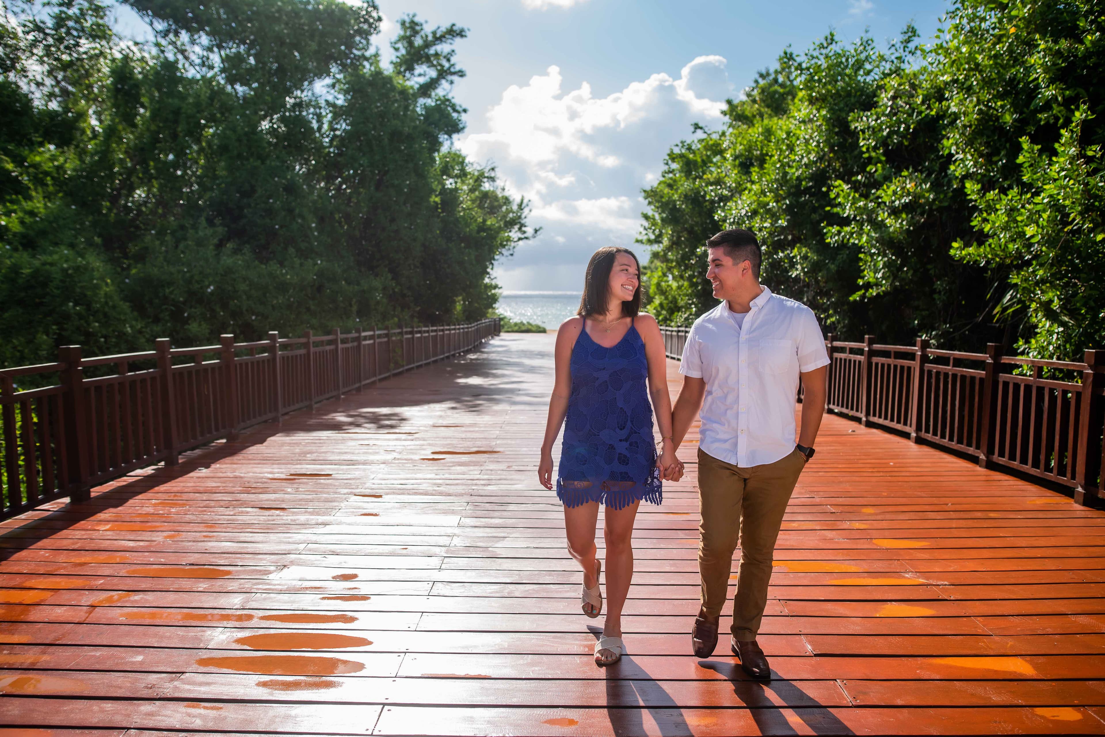 Eli and Hannah walking on a wooden bridge.